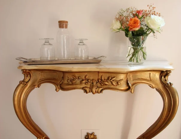 Console ancienne dorée avec bouquet de fleurs maison d'hôtes Domaine de Champouteau