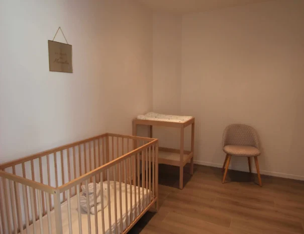 chambre bébé avec lit à barreaux dans le gîte La Bergerie au Domaine de Champouteau
